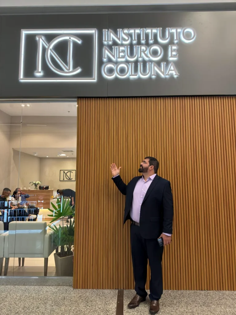 Fachada do Instituto Neuro e Coluna no Boulevard Shopping Camaçari, com letreiro iluminado e painel ripado de madeira