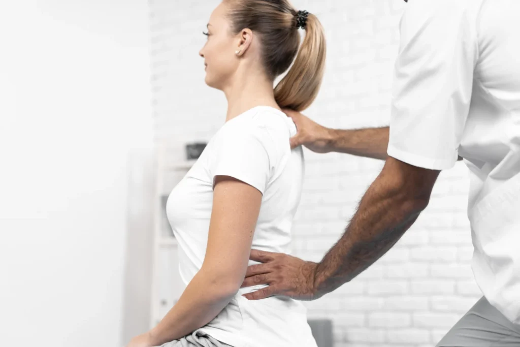 Profissional de saúde examinando a região lombar de uma paciente (imagem ilustrativa)